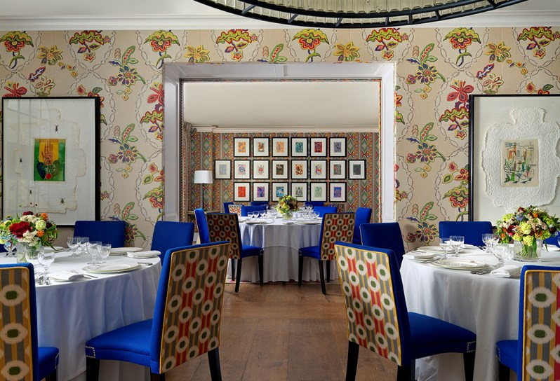 Two event spaces at Covent Garden Hotel set up with round tables, white table cloths and vases of flowers