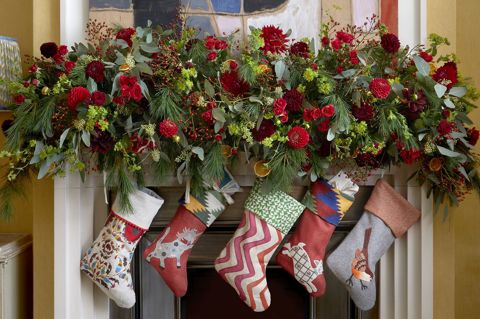 Firmdale festive stockings and Christmas decorations above a fireplace