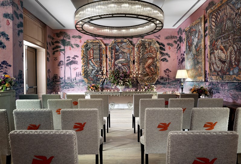 The Anrep private room with hand painted wallpaper by Melissa White, featuring Kit Kemp's mythical creatures, set up in theater style with comfortable chairs.
