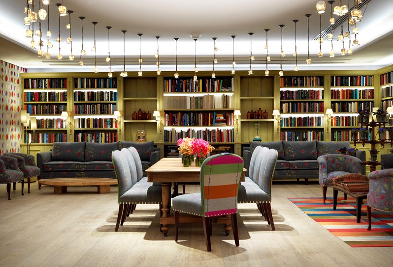 The intimate, book lined Reading Room with exciting lighting, set in boardroom style with comfortable grey sofas toward the back.