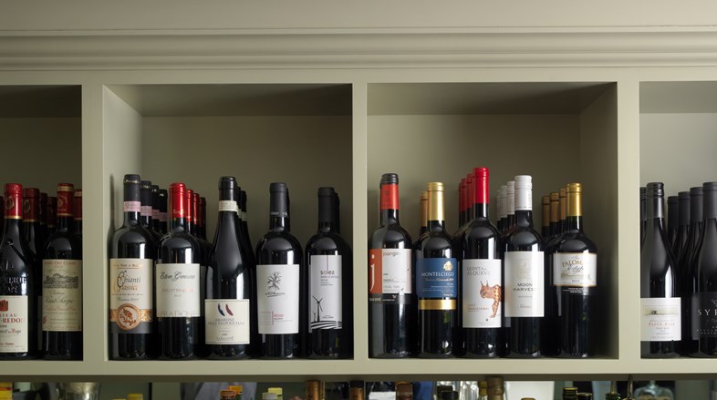 A selection of red wines on a shelf.