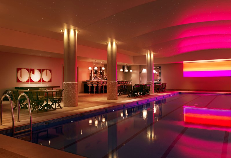 The swimming pool at Haymarket Hotel, with a bar edged in stone and complete with a ceiling covered in hundreds of fibre-optic lights.