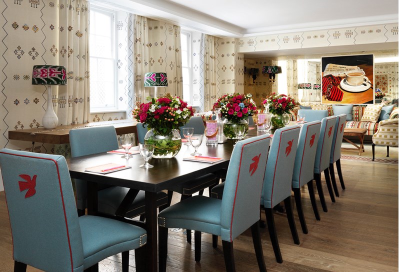 Rocklin room set for a meeting at a long table with glassware and notepads The room has cream printed wallpaper.