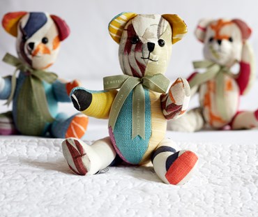 Willow bear patchwork soft toy covered in several of the colourful off cuts of Kit Kemp's fabric designs.