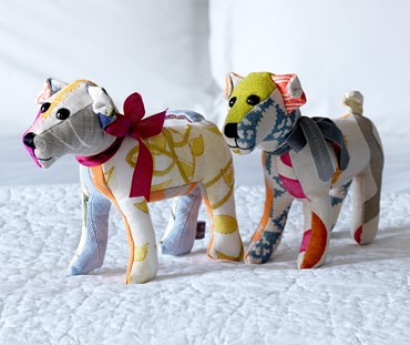 Two Tiffany pooch patchwork soft toys covered in several of the colourful off cuts of Kit Kemp's fabric designs.