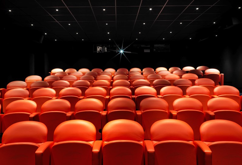 The screening room at Charlotte Street Hotel with rows of red leather cinema style seats.
