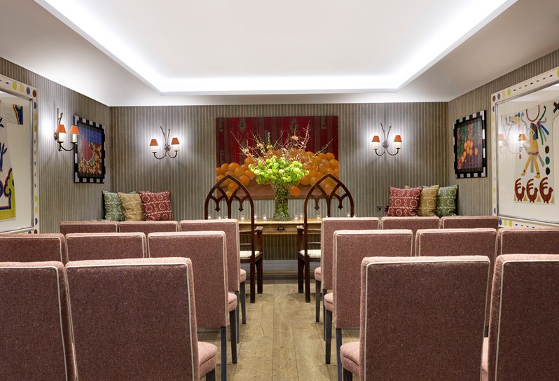 The Vanessa Bell Room setup for a wedding ceremony facing a large colourful painting.