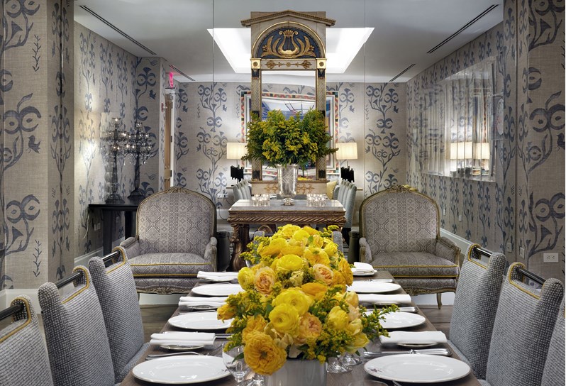 Lafayette Private dining room set up for lunch with a row of bright yellow flowers down the centre, beautiful china and glassware and line walls with a pretty graphic pattern.