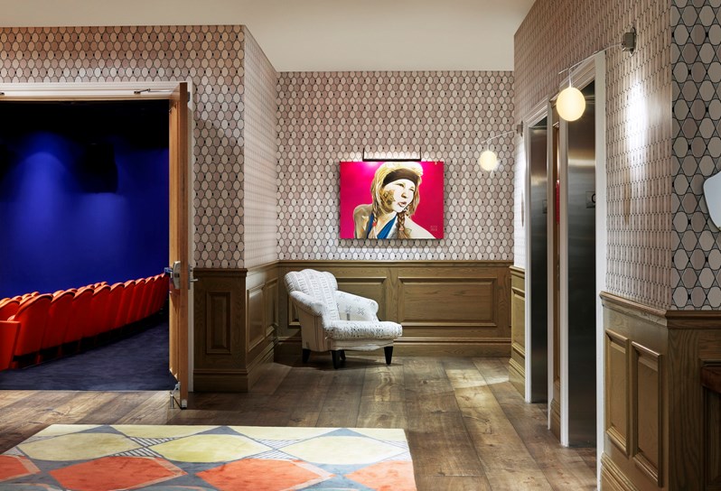 The Events floor lobby with colourful wallpapers and art looking through to the state of the art screening room with 99 red leather seats.