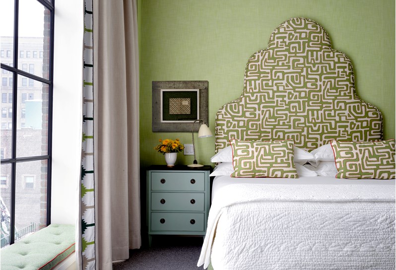 A beautiful bedroom with floor to ceiling windows, high graphic headboard and a colour scheme in green.