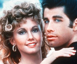 A close up image of Olivia Newton-John and John Travolta playing Sandy and Danny in classic musical film, Grease. - link to Grease
