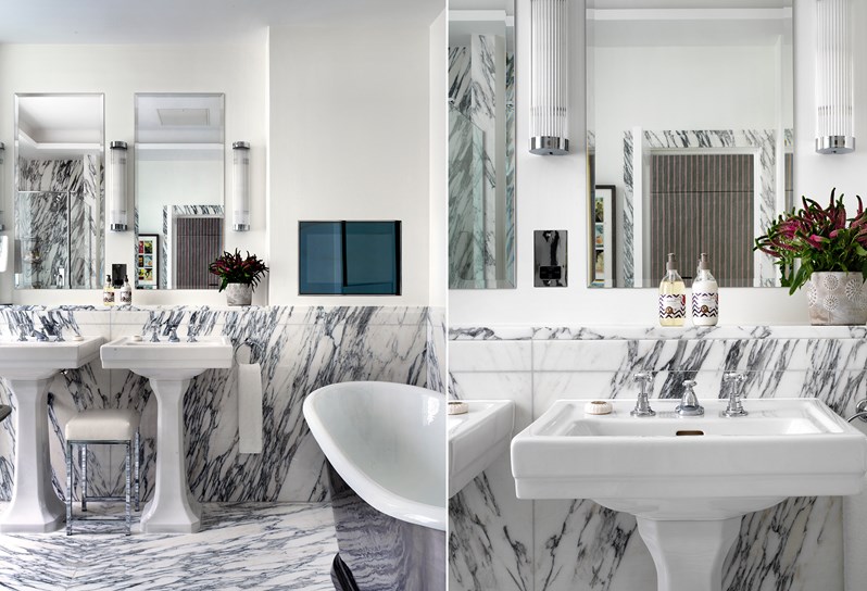 A marble bathroom containing a deep bathtub, a separate walk in shower, double basins, and a toilet.