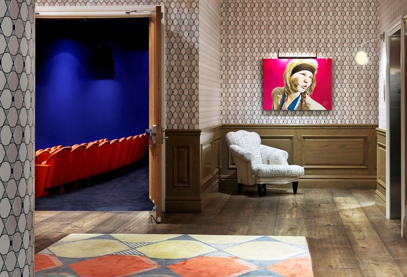 The events lobby at Crosby Street Hotel, in the foreground is a red column and in the background an open door looks through to the theatre