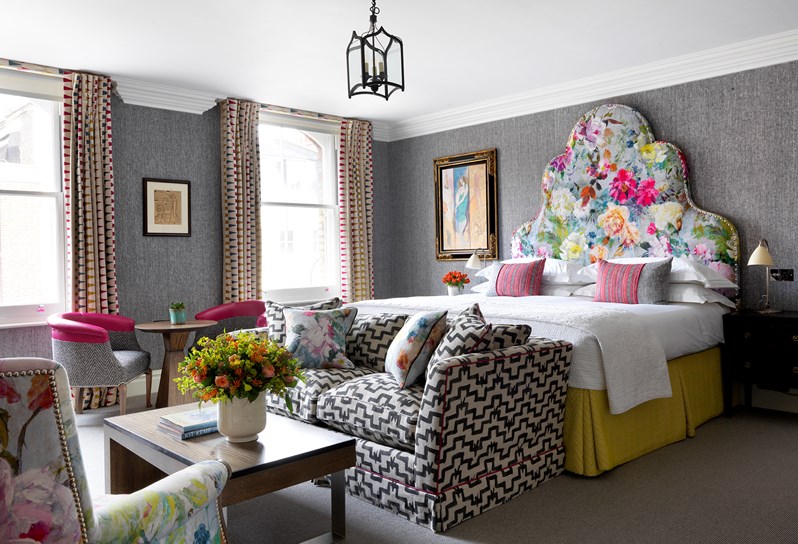 A bedroom with a gorgeous bright coloured floral headboard at Charlotte Street Hotel