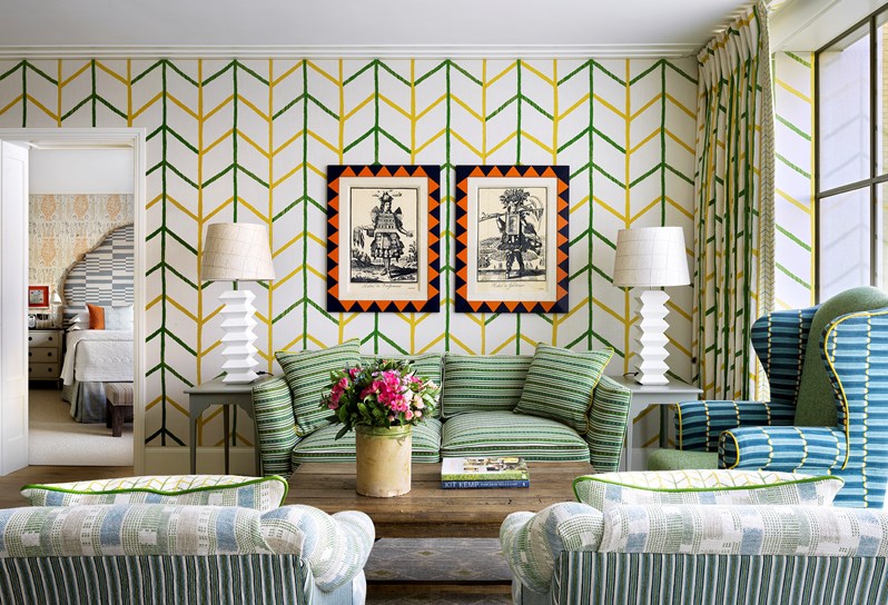 A vibrant suite with yellow and green striped walls and a green sofa