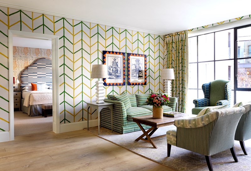 A vibrant suite with yellow and green striped walls and a green sofa