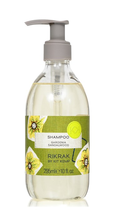 A 295ml plastic bottle of shampoo with pump dispenser scented with Gardenia Sandalwood. Label has a green friendly flowers design applied.