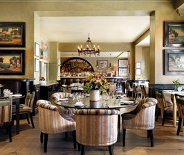 Brasserie Max restaurant with a round table surrounded by comfortable fabric chairs