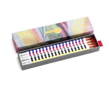 Kit Kemp's pencil box covered with a print for the fabric Book Ends. Sliding drawer removed from box showing 10 colourful striped pencils each with eraser and a different Firmdale hotel printed on it.