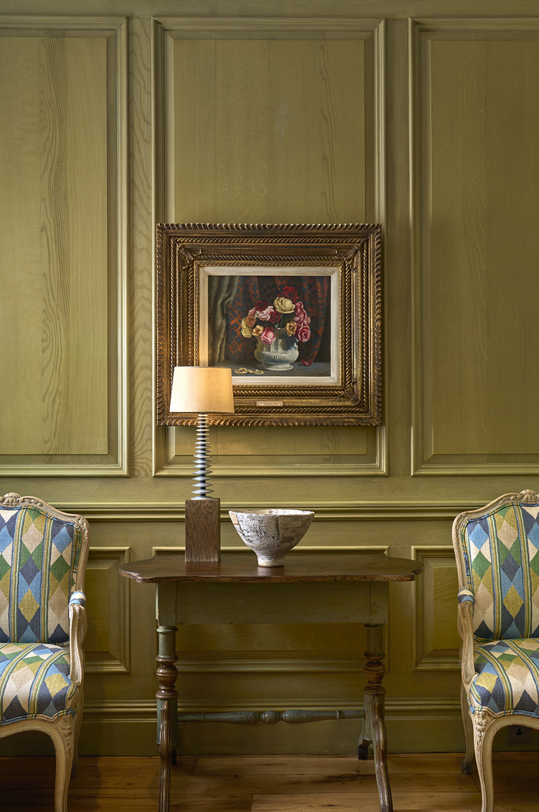 Close shot of artwork in the Library at Charlotte Street Hotel, with two chairs.