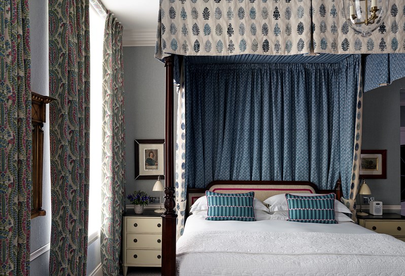 A four poster bed with beautiful blue curtains
