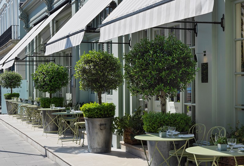 The Charlotte Street Hotel Oscar Terrace with green small tables and chairs laid out front of the hotel