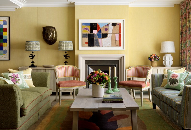 A colourful suite with yellow walls and a white fireplace