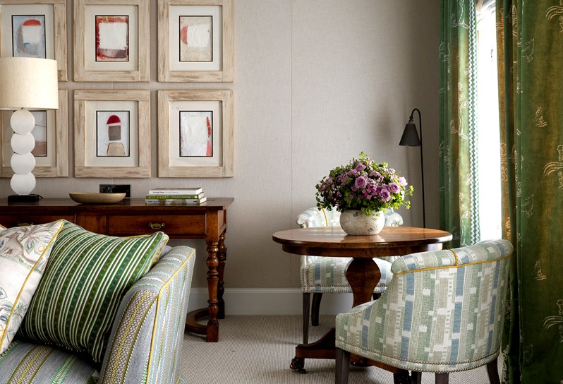 A beautiful drawing room with cream walls and a pale blue and green striped sofa and armchairs covered in a pale blue and green fabric