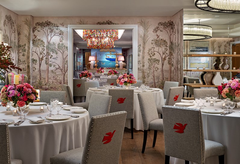 The private dining room at Crosby Street Hotel laid out for dinner on round tables