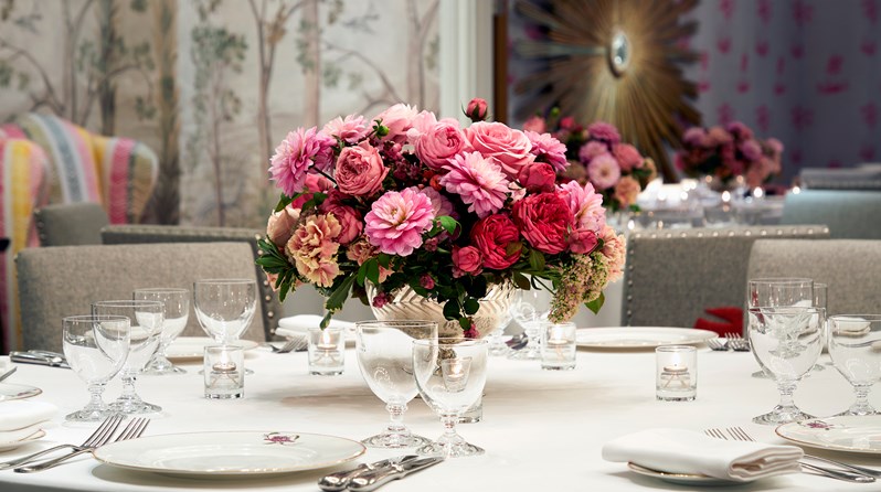 A colorful meeting room with a round table decorated with a bouquet of flowers