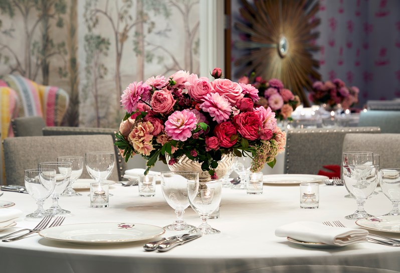 A colorful meeting room with a round table decorated with a bouquet of flowers