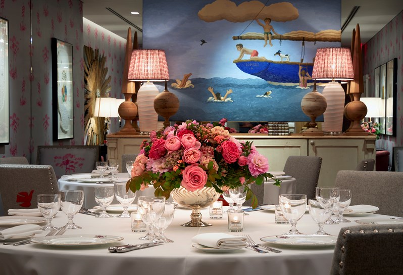 A colorful meeting room with blue walls and a round table decorated with a bouquet of flowers
