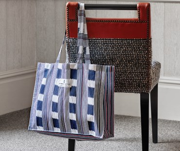 Lost and Found Bag For Life Navy is shown hung over a chair.