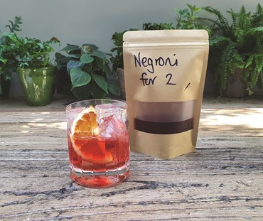 Negroni packaging with cocktail in a short tumbler.