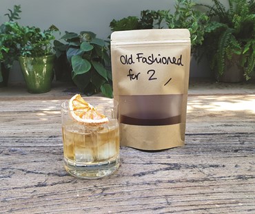 Old Fashioned packaging with cocktail in a short tumbler.