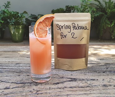 Spring Paloma packaging with cocktail in a tall glass.