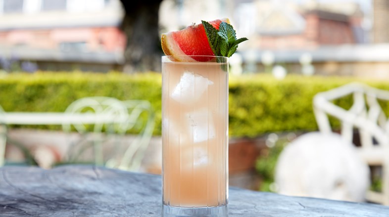 Spring Paloma cocktail topped with a grapefruit on Ham Yard Hotel's Roof Terrace