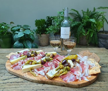 Complete brunch menu, served on a wooden serving board with two glasses of wine in the background.