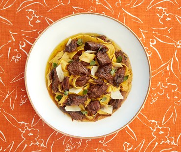 A bowl of beef ragu on a Kit Kemp's orange fabric design