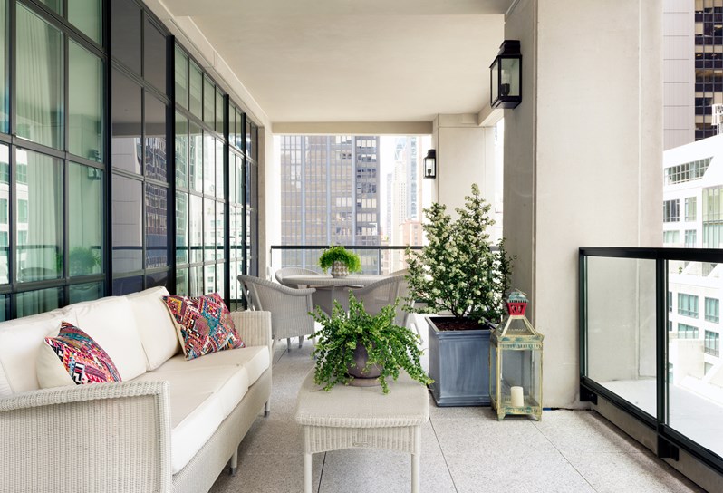A spacious terrace overlooking Manhattan with a dining table and lounge seating