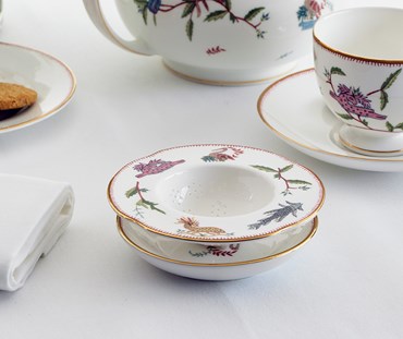 Picture of a table with teapot, teacup and strainer