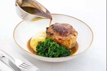 Pie with gravy in a bowl
