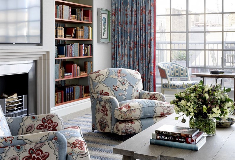 Two armchairs with floral fabrics are seen in a living space
