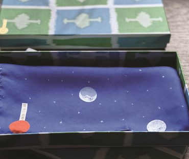 Over the moon pocket square. Displayed folded inside gift box featuring Kit Kemp's ozone green fabric