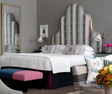 Side shot of Firmdale bed set displaying headboard, pillows, cushions and bedspread