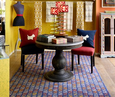 Close up of the Domino Rug with a table and chair in the Ham Yard Shop