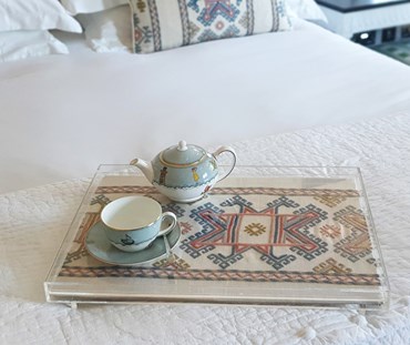 Acrylic Trays on a bed with the Ashen wood hand embroidered linen in Blue - Tray placed on the end of the bed