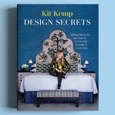 Front cover of Kit Kemp's book Design Secrets featuring her sat on a bed