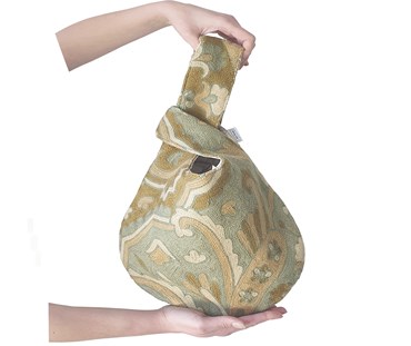 Hands holding knot bag in green embroidered fabric
