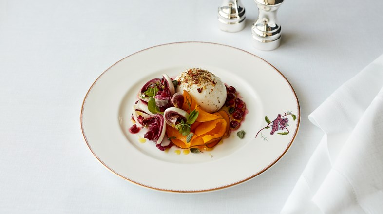 A burrata with chili and oregano, pickled pumpkin, bitter leaves and pomegranate.